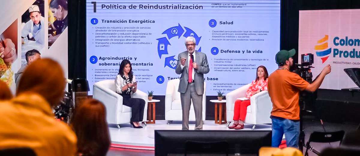 Descripción imagen: Ministro Germán Umaña frente a las cámaras y el público hablando por micrófono.