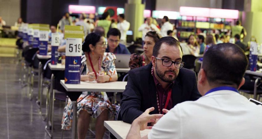 Hombres y mujeres en mesas, sentados dialogando.
